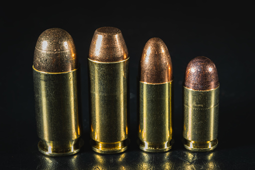 Macro photos of pistol cartridges of caliber 45, 10mm, 9mm and 380. High quality photo