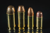 Macro photos of pistol cartridges of caliber 45, 10mm, 9mm and 380.