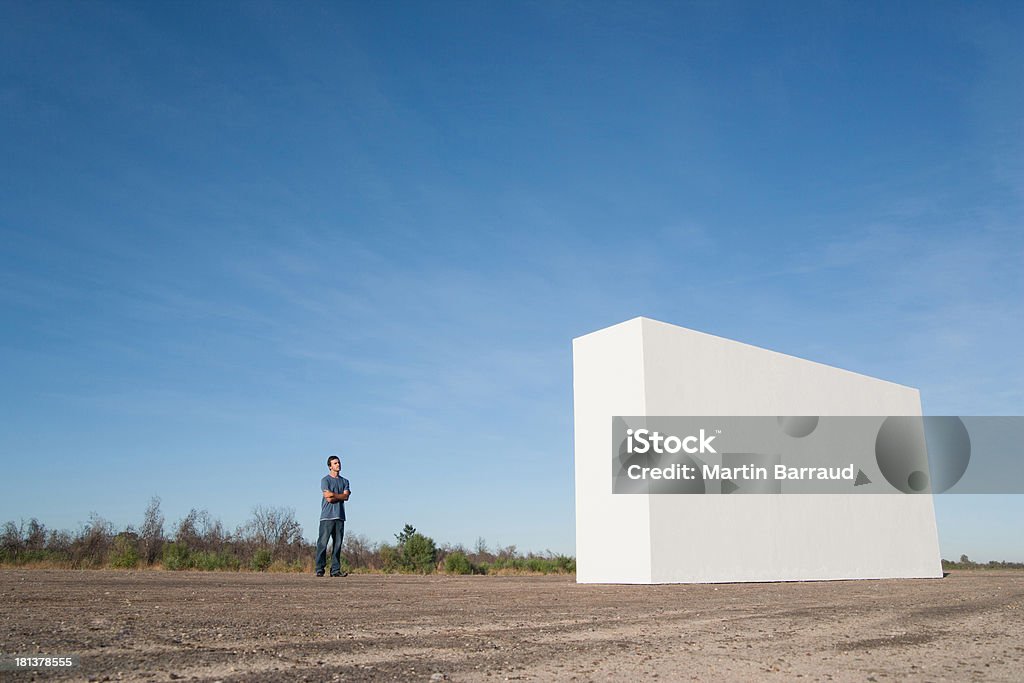 Homem de pé ao ar livre, olhando para a parede branca - Royalty-free 25-29 Anos Foto de stock