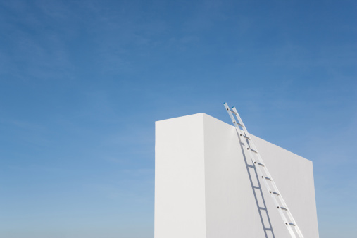 Ladder, building and a man construction worker on site for engineering, maintenance or repairs from below. Industry, safety and an electrician, handyman or contractor climbing a wall for inspection