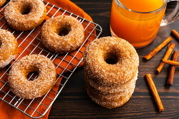 Baked Apple Cider Donuts with Cinnamon Sugar Coating Baked doughnuts cooling on a wire rack viewed from directly above apple juice stock pictures, royalty-free photos & images