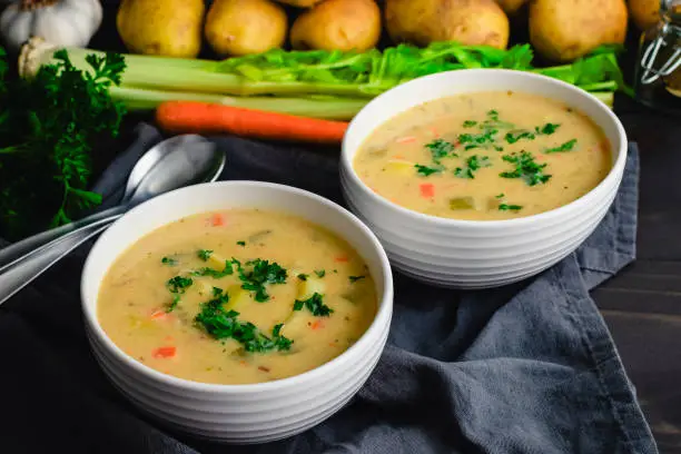 Bowls of vegetable soup with potatoes, celery, carrots, and garlic