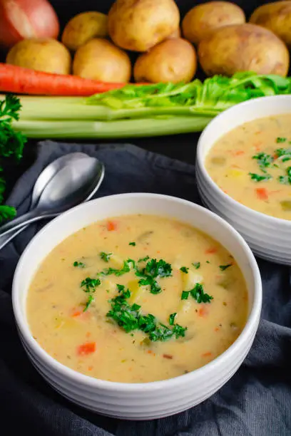 Bowls of vegetable soup with potatoes, celery, carrots , and garlic