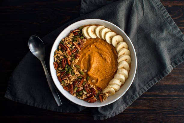 Pumpkin Pie Smoothie Bowl on a Wooden Table with a Spoon