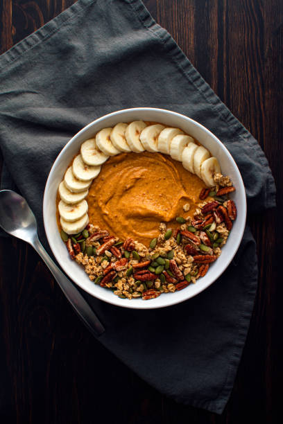 Pumpkin Pie Smoothie Bowl on a Wooden Table with a Spoon
