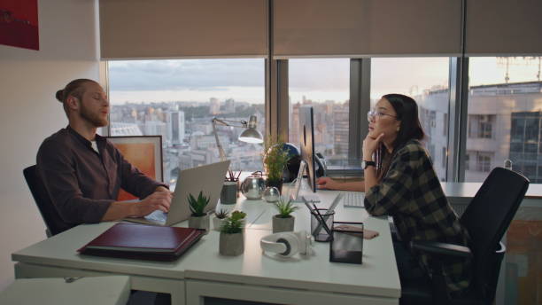 istock Two people brainstorming at sunset view office close up. Colleagues discussing 1813833163