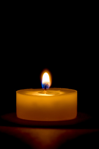 Macro of a tea light candle Isolated on black, melted wax