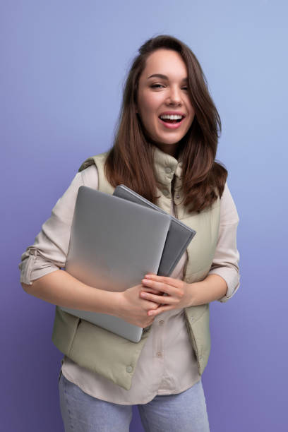 istock positive 30s lady student holding documents and laptop on empty space background 1813859008