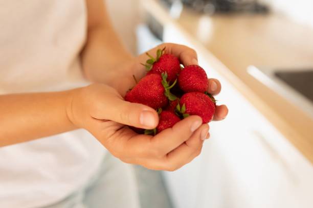istock hands holding juicy red strawberries 1813859573