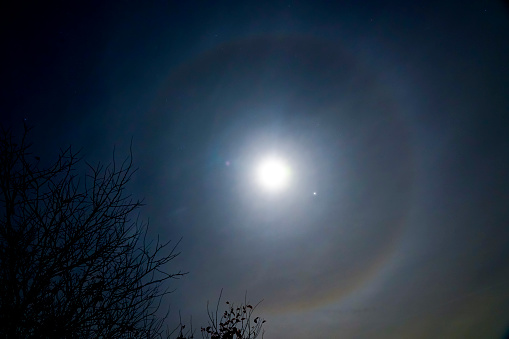 A moon halo, an optical illusion that causes a ring around the moon. The natural phenomena caused by ice in the atmosphere. The moon halo was seen in Hertford, UK.