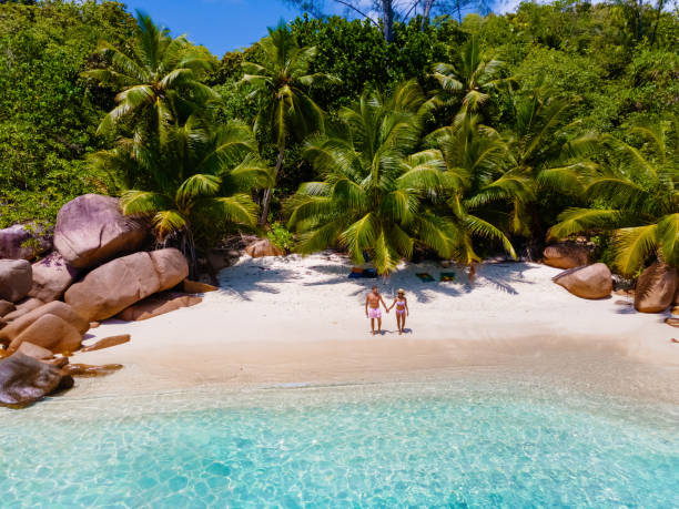 istock Praslin Seychelles tropical island with withe beaches and palm trees, couple men and women mid age on vacation at the Seychelles visiting the tropical beach of Anse Lazio Praslin Seychelles 1813883295