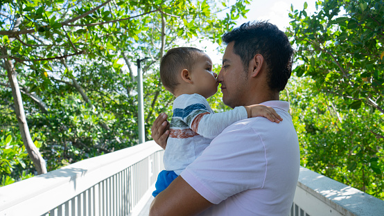 man sharing with his baby on a bridge in the middle of nature