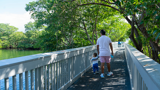 man sharing with his baby on a bridge in the middle of nature