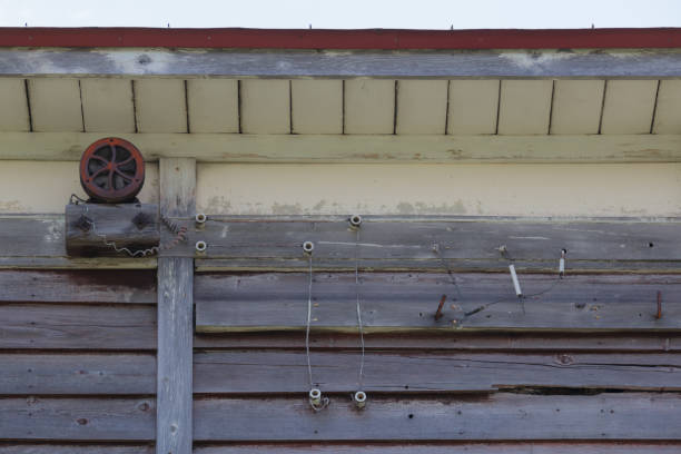 istock Old rusty alarm on wooden school building 1814014136
