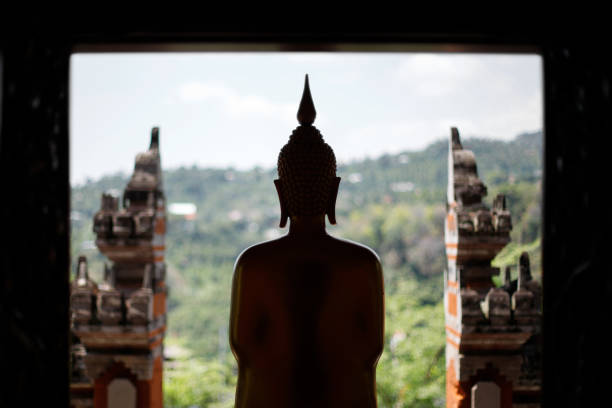 Buddha statue silhouette against balinese gate. High quality photo