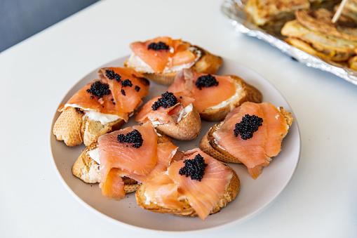 Delectable Smoked Salmon Canapés Topped with Caviar on a Porcelain Plate