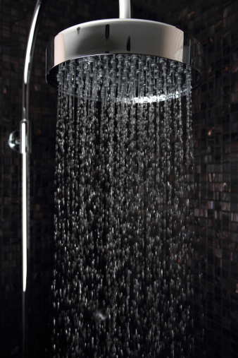 Modern round shower head in tiled shower