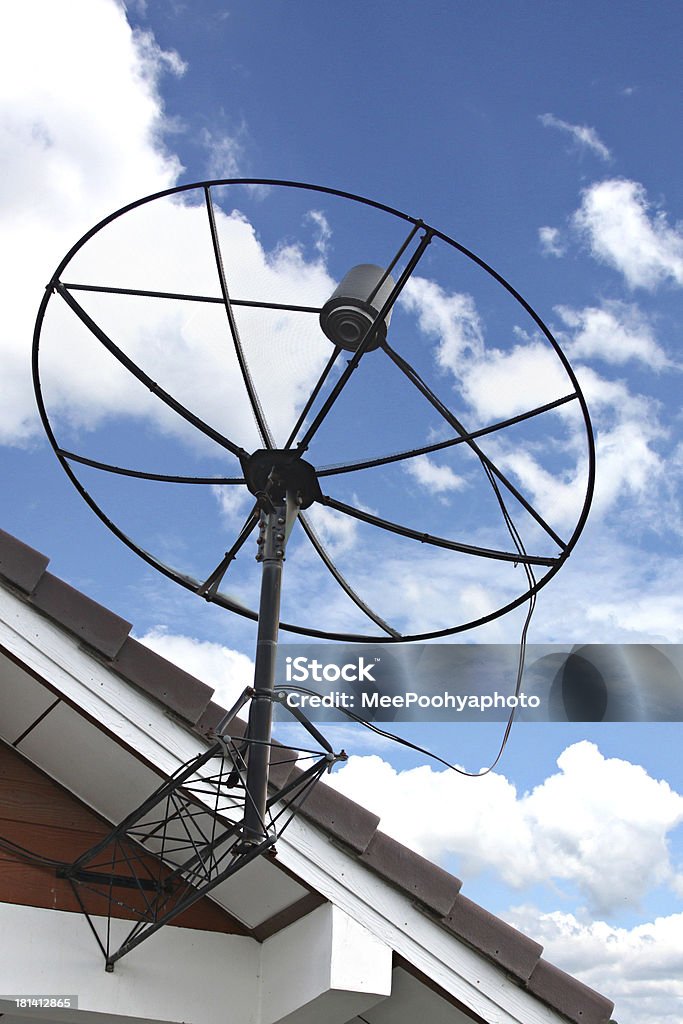 Antena parabólica atrapado en el techo de la casa sobre cielo azul. - Foto de stock de Amor a primera vista libre de derechos