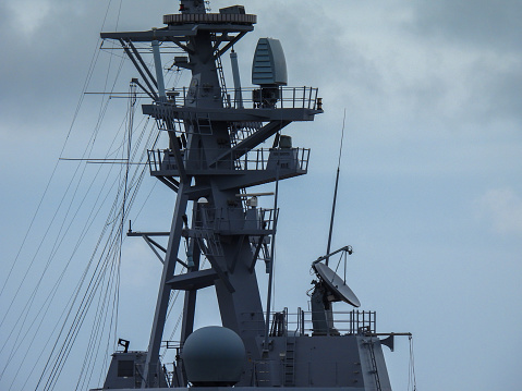 The top of the communications mast of HMAS Sydney, one of three Hobart Class destroyers of the Royal Australian Navy docked at Garden Island naval base in Sydney Harbour.  This image was taken on an overcast and windy afternoon on 25 November 2023.