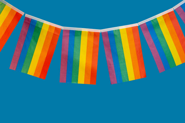 istock Many small rainbow flags hang against a blue background 1814173243