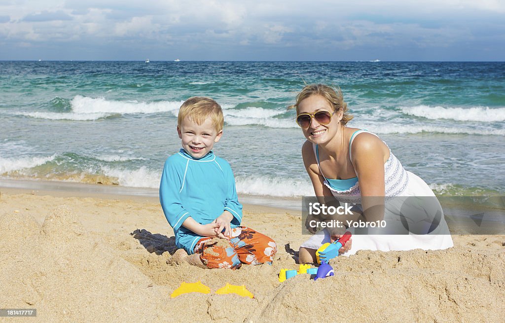 Famiglia giocando con la sabbia in spiaggia - Foto stock royalty-free di Acqua