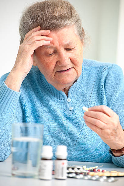 istock senior woman taking her medicine 181417898