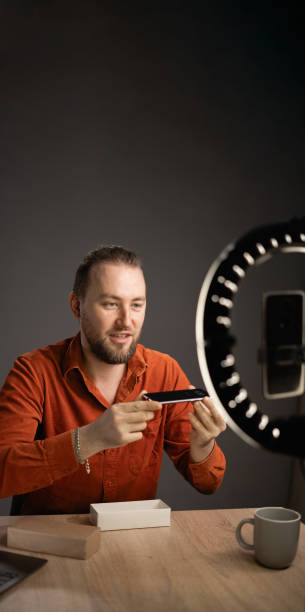 istock Attractive man blogger creating online content for his tech channel, daily vlog, unboxing a brand new smartphone at home 1814210106