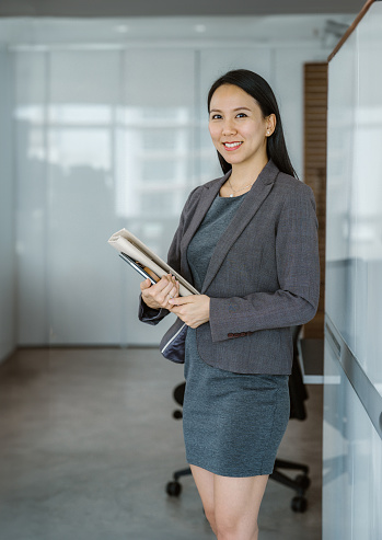 Portrait of smiling Asian saleswoman with file at real estate office. - Real estate x Client consultation in Southeast Asia Concept.