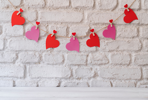 Love hearts hanging on rope on wall for valentine’s day