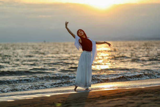 istock Beautiful lady dancing at beach side 1814270223