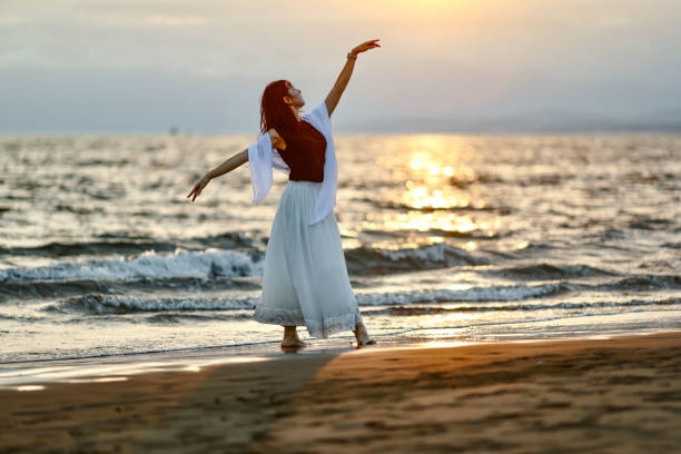 istock Beautiful lady dancing at beach side 1814270740