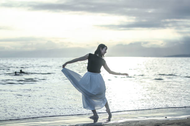 istock Beautiful lady dancing at beach side 1814270743