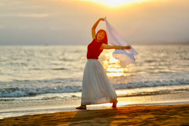 istock Beautiful lady dancing at beach side 1814271257