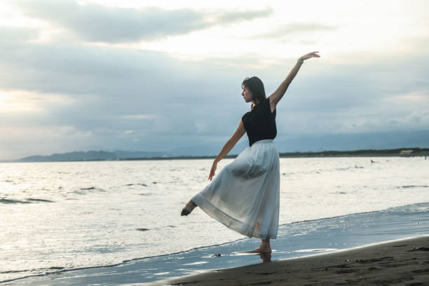 istock Beautiful lady dancing at beach side 1814271264
