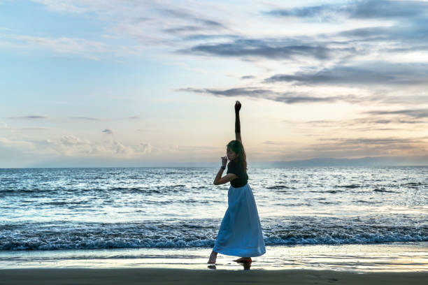 istock Beautiful lady dancing at beach side 1814271270