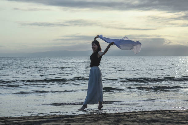 istock Beautiful lady dancing at beach side 1814273358