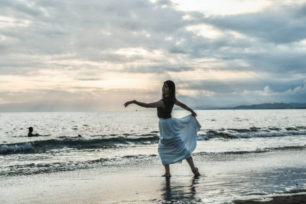 istock Beautiful lady dancing at beach side 1814275020