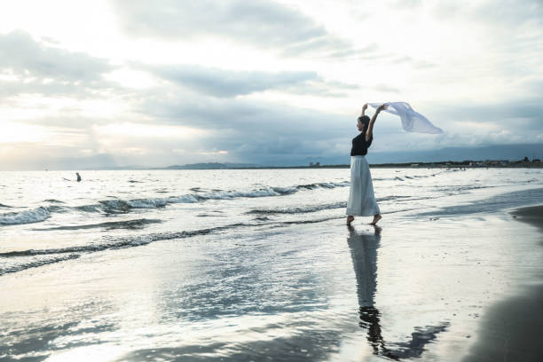 istock Beautiful lady dancing at beach side 1814275455