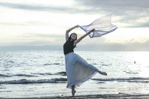 istock Beautiful lady dancing at beach side 1814275978