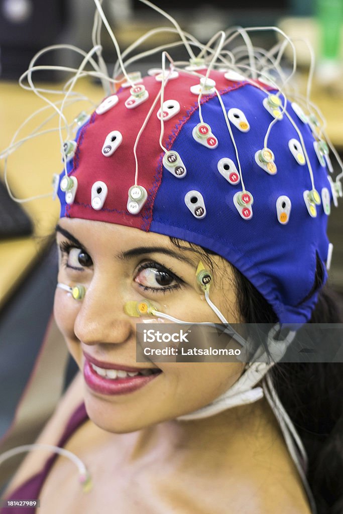 Psychophysiological measurements Picture of a latin girl with electrodes in her face, chest and head to record psychophysiological signals for research purposes. Electrocardiogram (ECG), electroencephalogram (EEG) and electrooculogram (EOG) being recorded. Adult Stock Photo