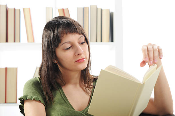 istock woman reading a book , bookshelf on background 181430045