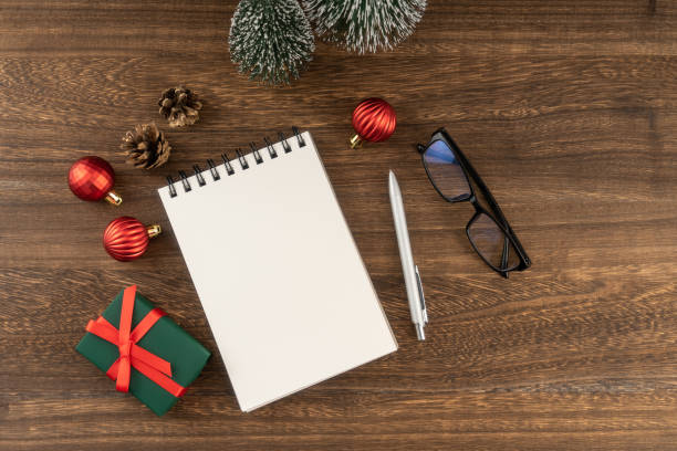 istock Holiday decorations and notebook on wooden table from above, Christmas planning concept. 1814303502