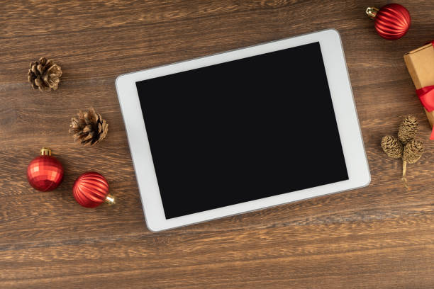 istock Digital tablet with Christmas decorations on wooden background. 1814304620