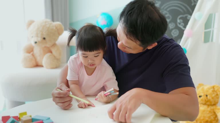 Asian father painting with kid