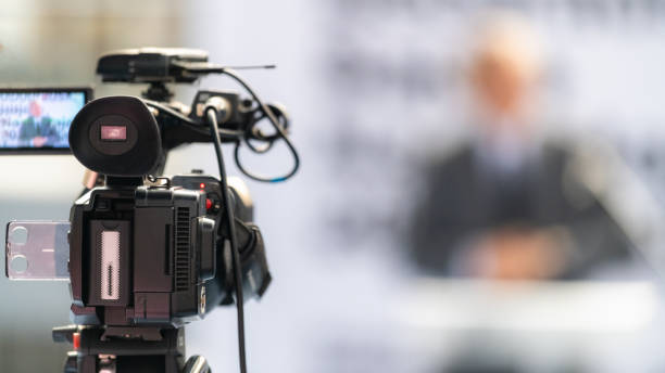 istock TV camera records a speaker on stage, delivering impactful insights and engaging the audience, on fair 1814360882