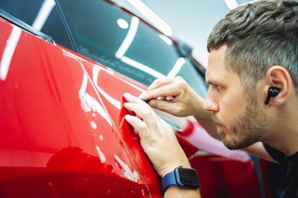 istock The process of installing protective film on the new red car. 1814361944