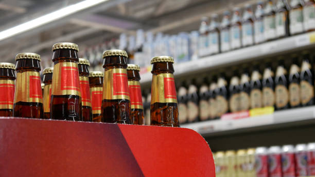 Close-up of many golden-red beer bottles in a beer department stock photo