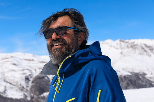Active lifestyle, Portrait Vital  men snowboarder, enjoying on sunny ski resorts.  Snowcapped mountain  Alps  ski area. Ski resort Livigno. italy, Europe.