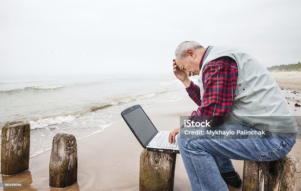 老人男性とノートパソコンにビーチ - 1人のロイヤリティフリーストックフォト