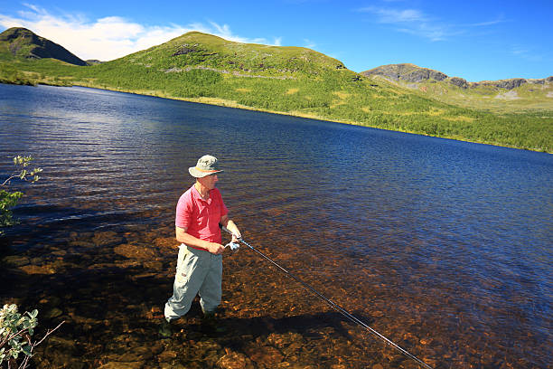 istock fisherman reels the lure in 181439455